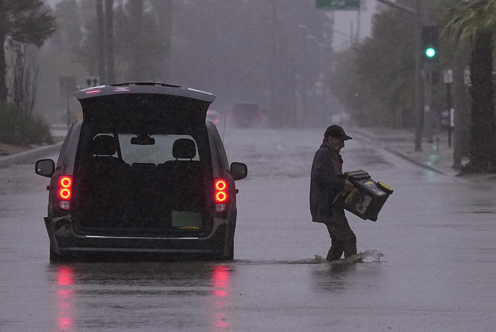 Sun., Aug. 20: A motorist removes belongings from his vehicle after becoming stuck in a flooded street in Palm Desert, Calif.