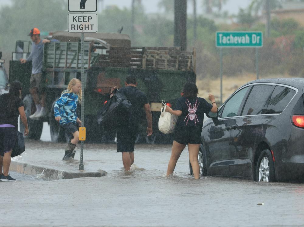 Motorists leave their vehicle stuck on a flooded road during heavy rains from Tropical Storm Hilary in Palm Springs, Calif., on Sunday.