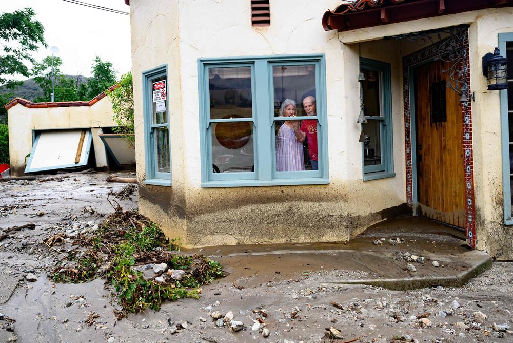 Mon., Aug. 21: Residents trapped in their home peer out a window while waiting for help in Yucaipa, California.