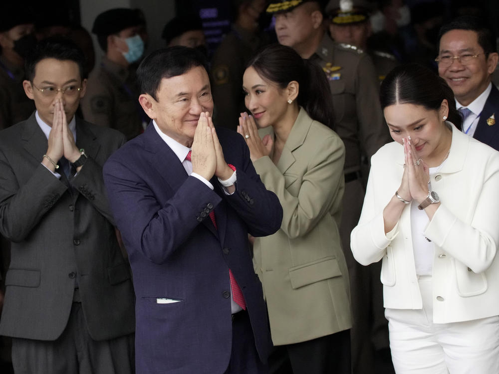 Thailand's former Prime Minister Thaksin Shinawatra, foreground, with, from left, his son Phantongtae, his daughters Pinthongta and Paetongtarn, arrive at Don Muang airport in Bangkok, Thailand, Tuesday, Aug. 22, 2023.