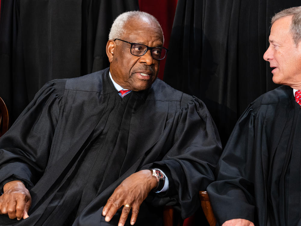 Associate Justice Clarence Thomas, left, talks to Chief Justice John Roberts during the formal group photograph at the Supreme Court in Washington, D.C., on Oct. 7, 2022.