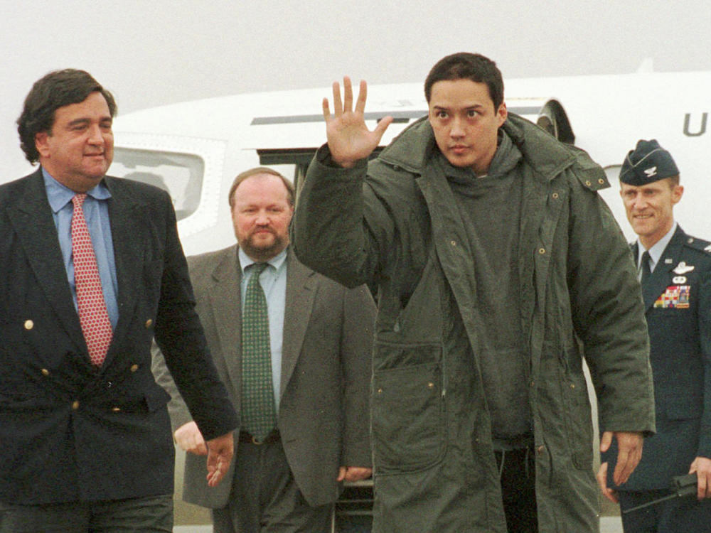 Evan Hunziker of Tacoma, Wash., waves upon his arrival at the Yokota Air Base in Japan on Nov. 27, 1996. Hunziker,  was jailed for three months in North Korea on spy charges, was freed and arrived at the air base with then U.S. Rep. Bill Richardson, D-N.M., left, who negotiated his release.