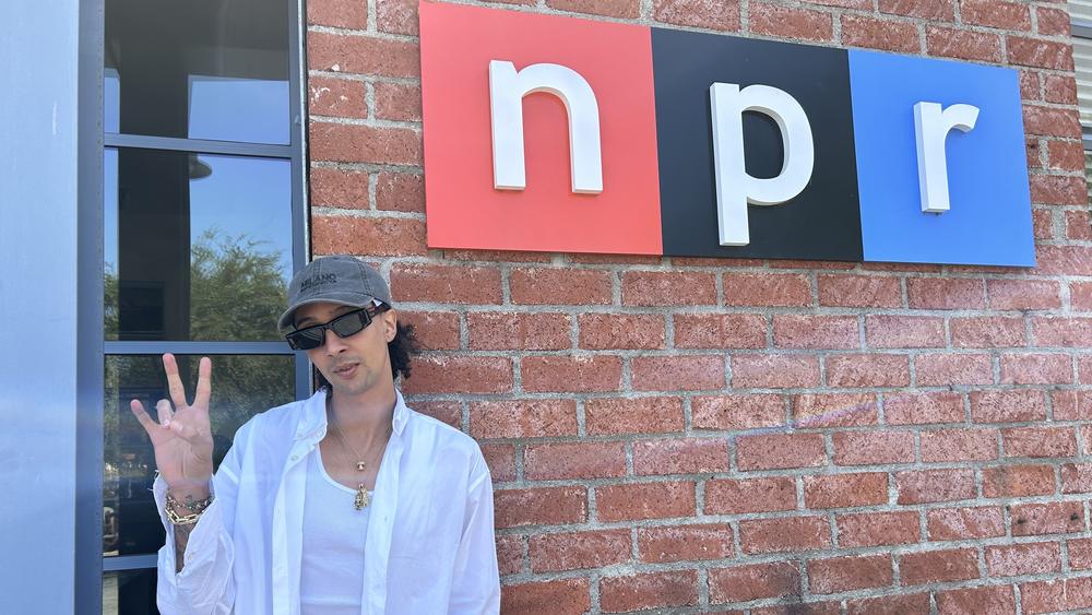 Italian rapper Ghali poses in front of the NPR logo at NPR West headquarters.