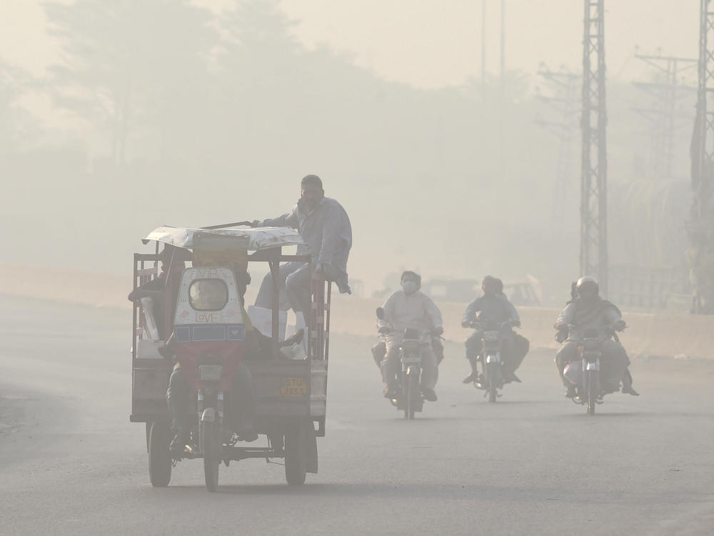 Commuters make their way down a smoggy road in Lahore, Pakistan in 2022. Extreme heat waves make air pollution, like smog, worse.