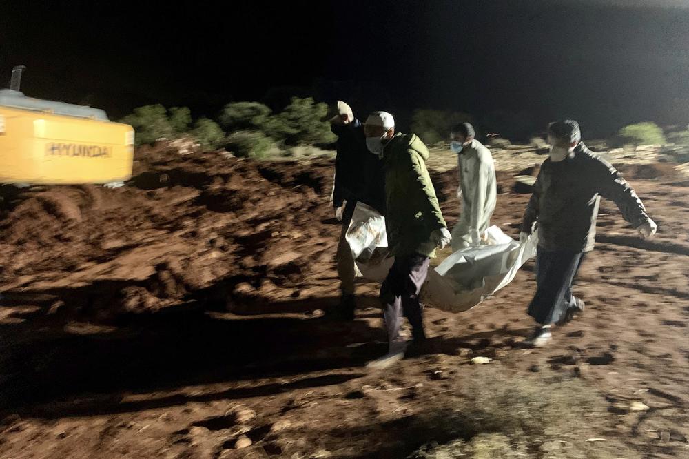 Workers bury the bodies of victims of recent flooding caused by Mediterranean storm Daniel near the city of Derna, Libya, late Tuesday, Sept. 12.