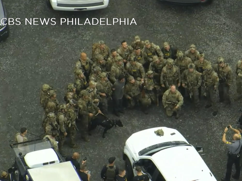 In this image from video provided by CBS NEWS Philadelphia, law enforcement officers pose for a group photo with Danelo Cavalcante after his capture in rural Pennsylvania on Wednesday, Sept. 13, 2023.