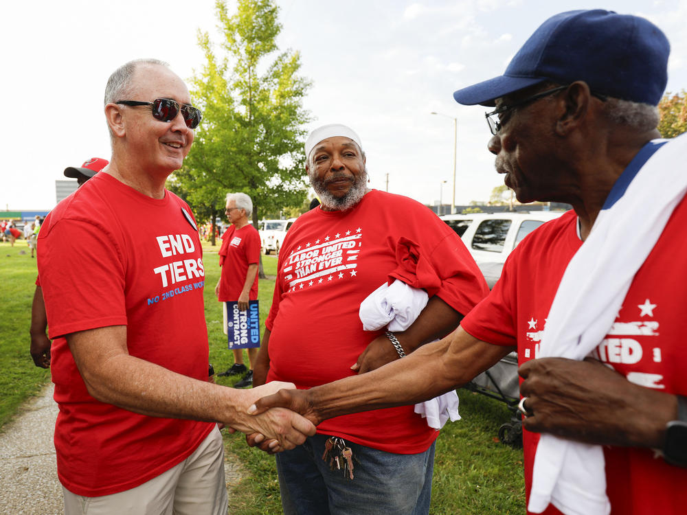 UAW President Shawn Fain talks with union members before marching in the Detroit Labor Day Parade in Detroit on Sept. 4, 2023. Fain has adopted a much more confrontational attitude towards automakers than previous UAW leaders.