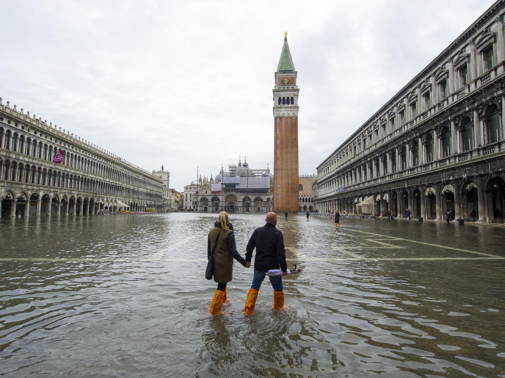 A couple walks in a flooded Saint Mark's Square during high waters on Nov. 19, 2013, in Venice, Italy.