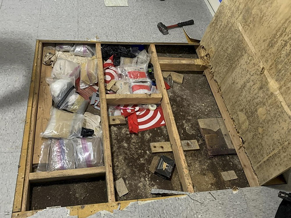 In this photo provided by the New York City Police Department, a trap door leans open over narcotics, including fentanyl, and drug paraphernalia stored in the floor of a day care center, Thursday, Sept. 21, 2023, in New York.