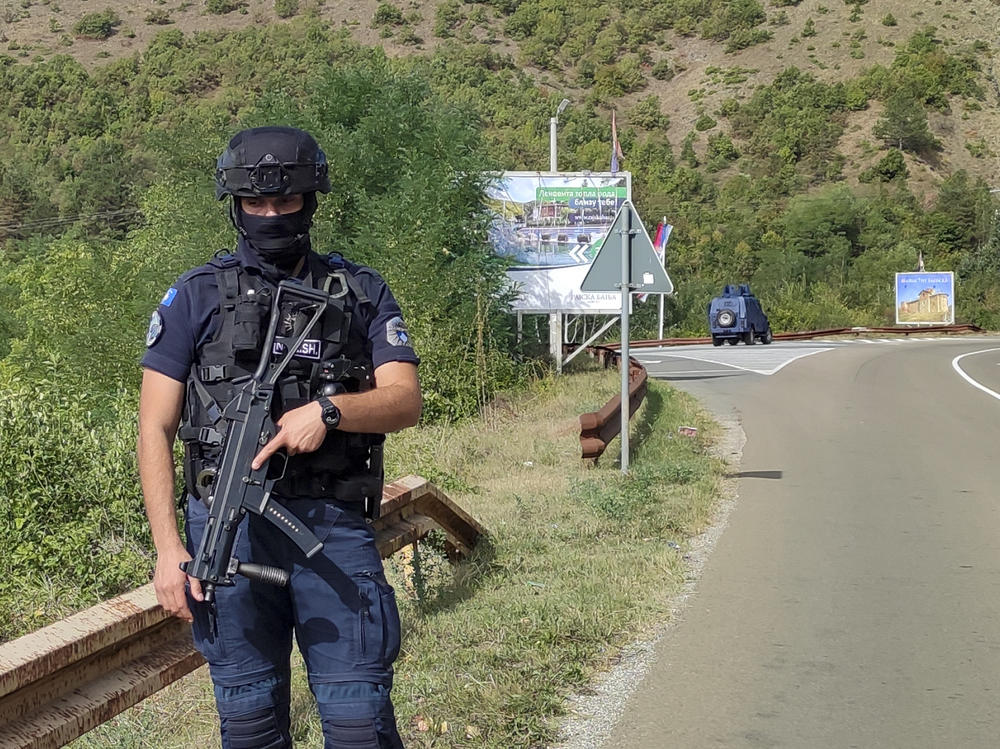 A Kosovo police officer guards the road near the village of Banjska, 55 kilometers (35 miles) north of the capital Pristina, northern Kosovo, Sunday, Sept. 24, 2023. Prime Minister Albin Kurti on Sunday said one police officer was killed and another wounded in an attack he blamed on support from neighboring Serbia, increasing tensions between the two former war foes.