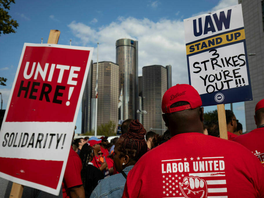 With the General Motors world headquarters in the background, United Auto Workers members attend a solidarity rally as the UAW strikes the Big Three automakers on Sept. 15 in Detroit. President Biden will join the workers in solidarity on Tuesday.