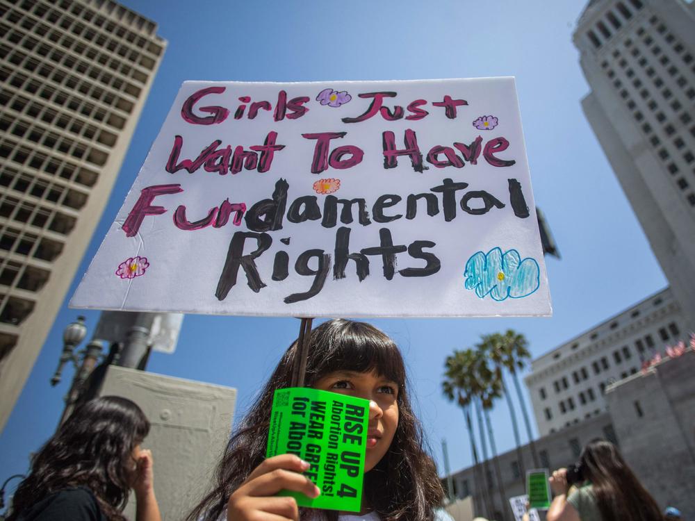 As more states pass abortion restrictions, confusion over terms shows up in hospitals and courtrooms. Camila Galvez holds a sign during a march for abortion rights in Los Angeles in April 2023.