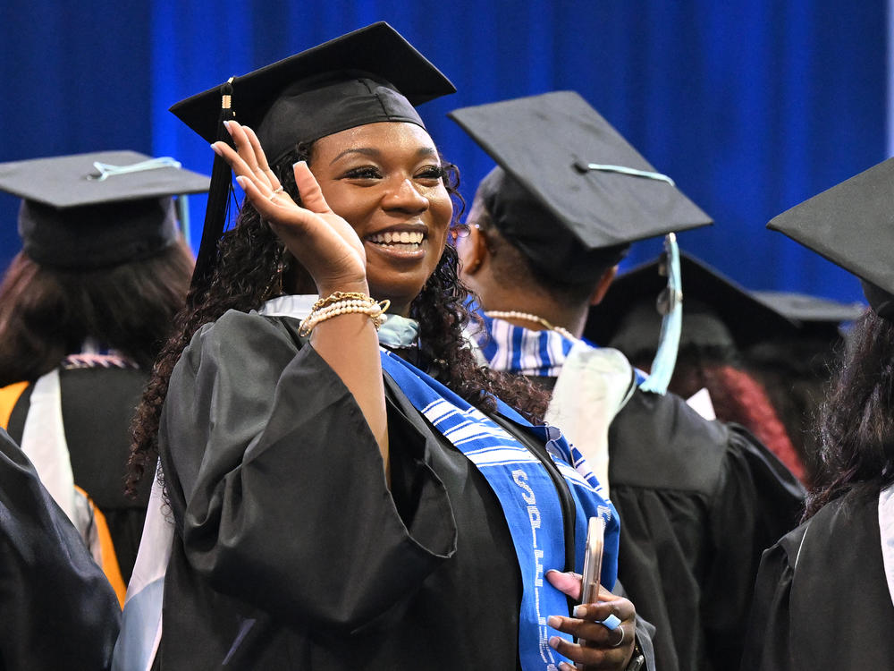 A Spelman College graduate waves during the school's 2023 commencement ceremony on May 21. Recent college graduates are due to make their first student loan payments in the coming weeks.