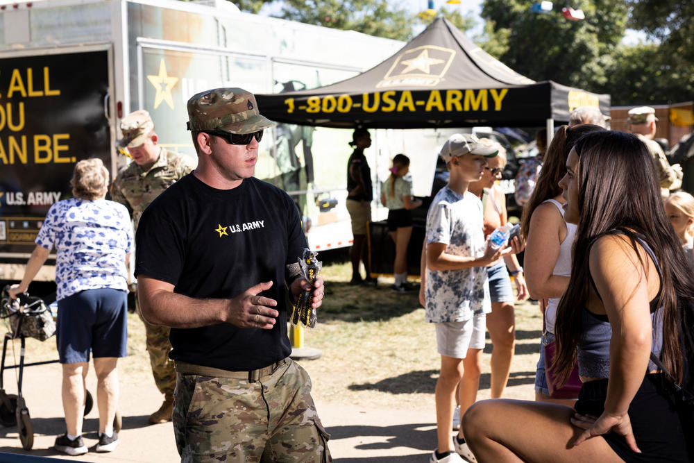 Staff Sgt. Joshua Spearman talks to Harmony Cook and her mother, Tara, at the Army recruitment tent at the Minnesota State Fair in Falcon Heights, Minn., on August 31.