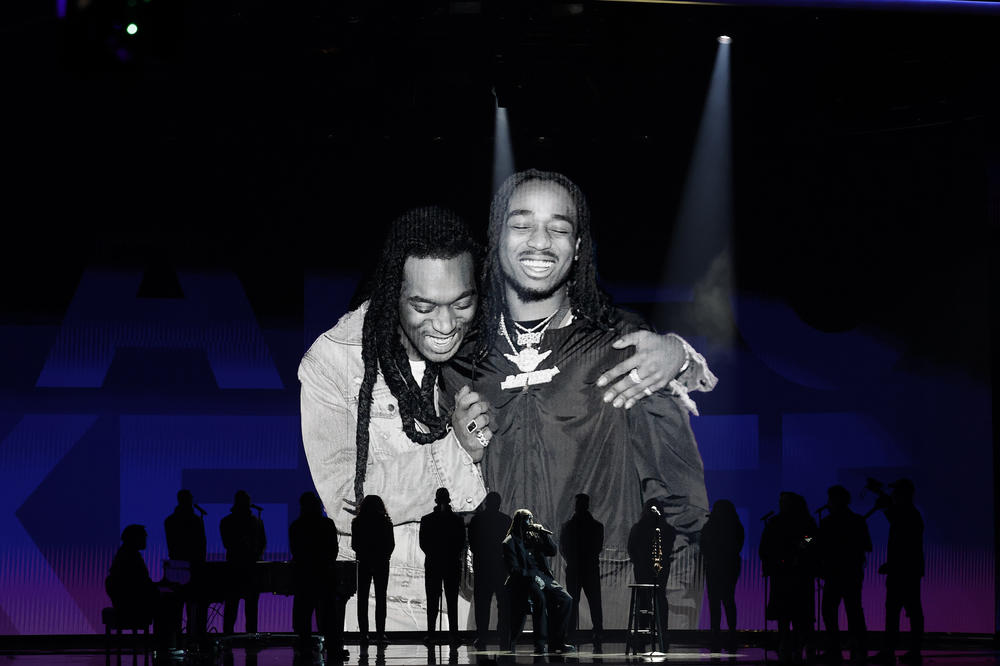 Quavo (center, seated) performs while an image of him and the late Takeoff is projected on a screen during the 65th GRAMMY Awards.