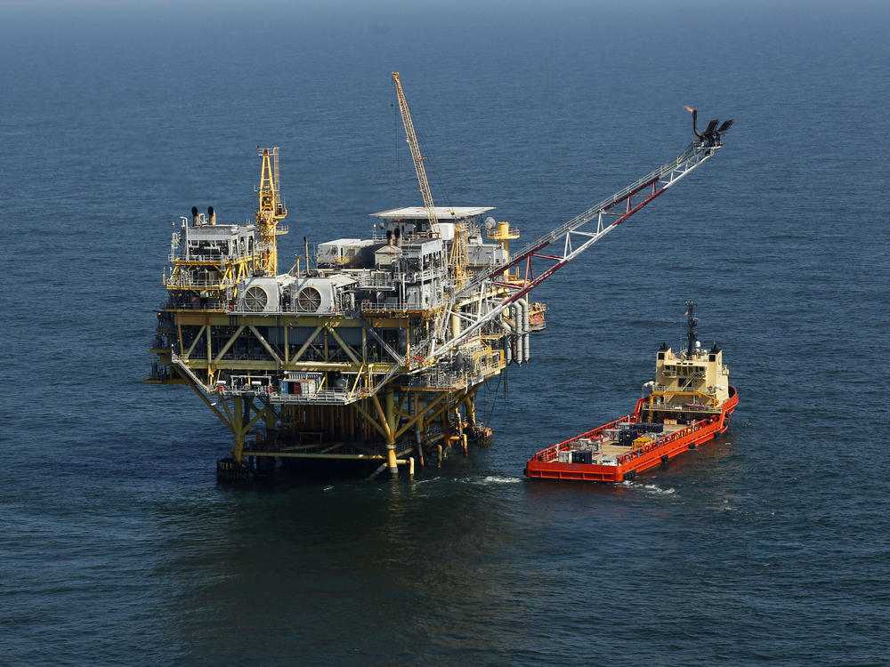 This April 10, 2011, file photo, shows a rig and supply vessel in the Gulf of Mexico, off the coast of Louisiana. The Biden administration has proposed up to three oil and gas lease sales in the Gulf of Mexico over the next five years.