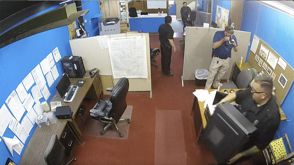 This image made from surveillance video provided by the Marion County Record shows Marion, Kan., Police Department confiscating computers and cellphones from the publisher and staff of the Marion County Record on Aug. 11, 2023.