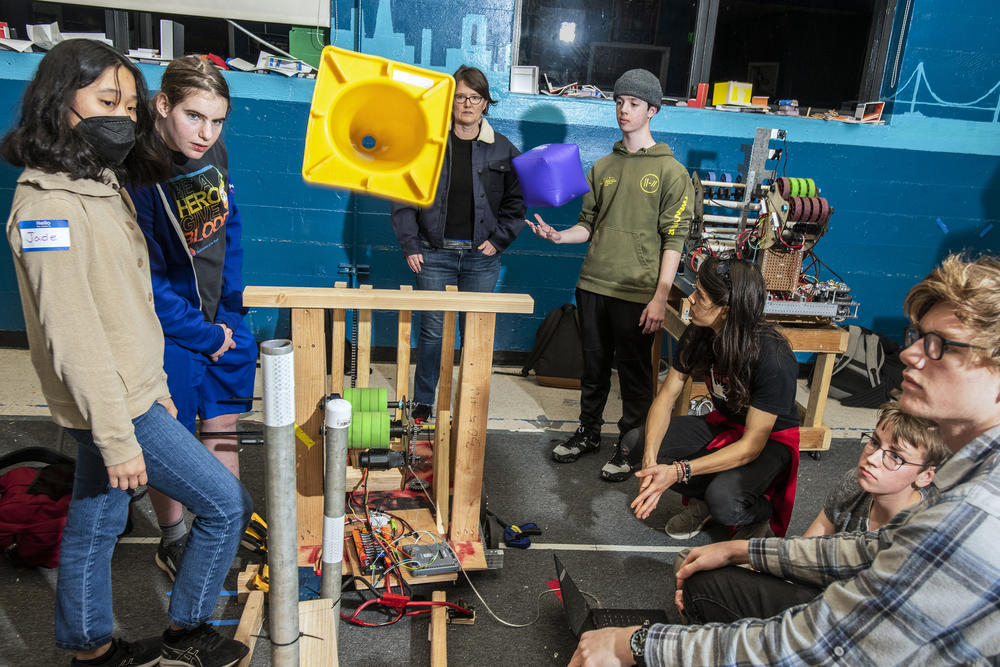 Team 5419 Berkelium team members, from Berkeley High School in Berkeley, Calif., test a prototype system to shoot cones onto poles. Caroline Soffer (second from left), 16, is a competitive gymnast and a designer. 