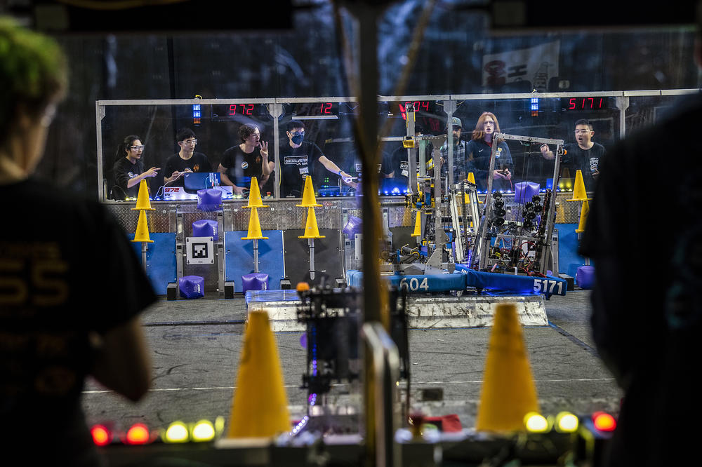 <strong>The finals of the 2023 Silicon Valley Regional:</strong> After rushing throughout the match to place cones on poles and cubes in slots to score, the teams earn a large point bonus at the end by cooperating with their alliance partners to balance all three robots on an unstable, tilting platform.