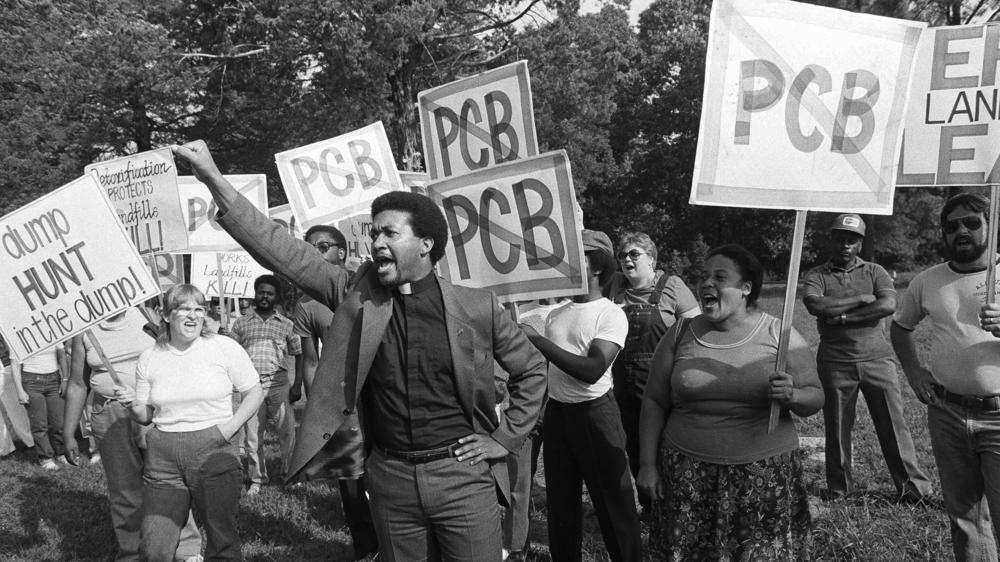 Rev. Ben Chavis, right, raises his fist as fellow protesters are taken to jail at the Warren County PCB landfill near Afton, N.C., on Sept. 16, 1982.