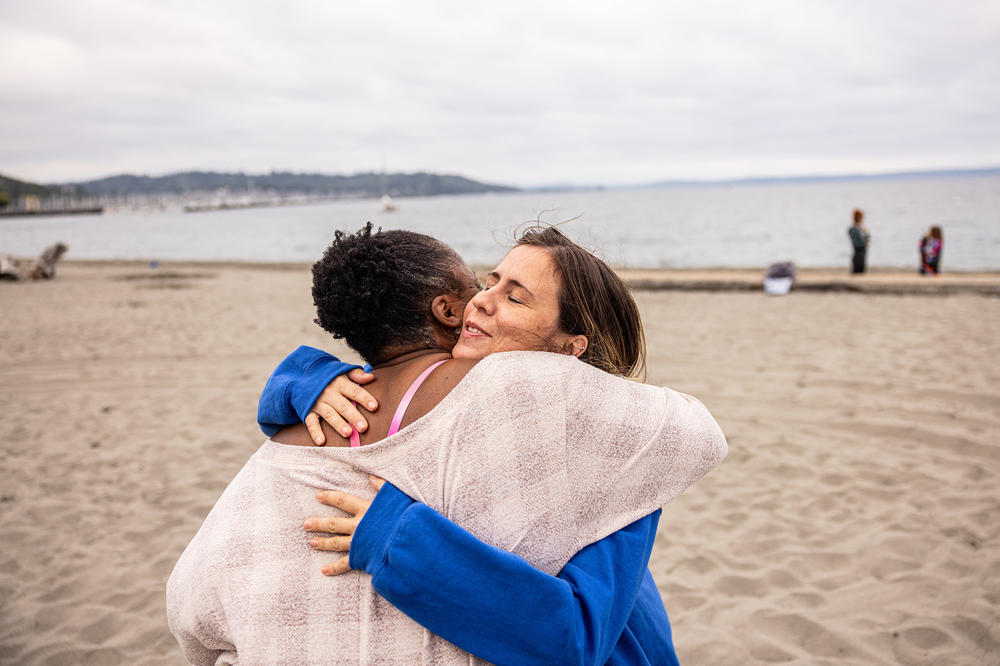 Audrey Nassal, right, hugs plunger Mikki Smith. Nassal started this group's Sunday morning dip earlier this year. As the gathering has grown, she has refined her pitch to anyone who might be tempted to join: 