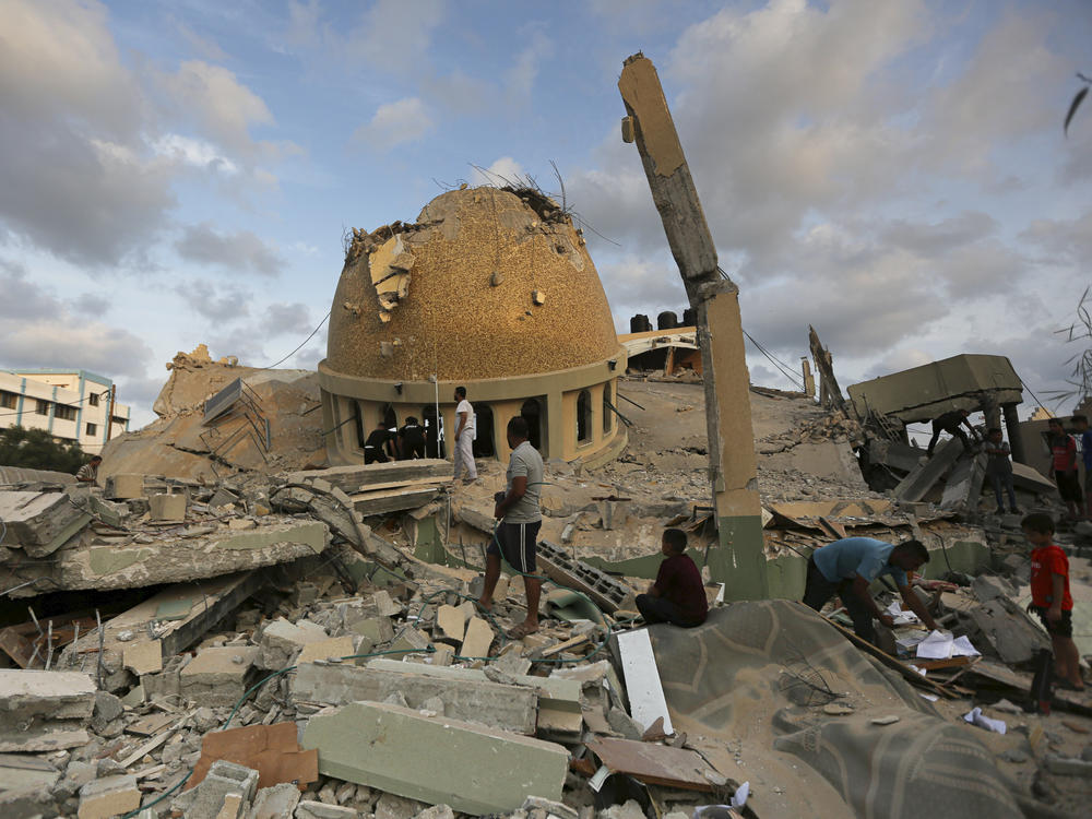 People stand outside a mosque destroyed in an Israeli air strike in Khan Younis, Gaza Strip, on Sunday.