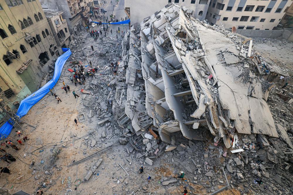 Sun., Oct. 8: People inspect the ruins of a building destroyed in Israeli strikes.