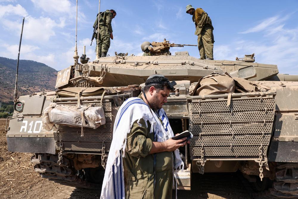 Sun., Oct. 8: An Israeli sodleir prays standing in front of a Merkava tank on the outskirts of the northern town of Kiryat Shmona near the border with Lebanon.