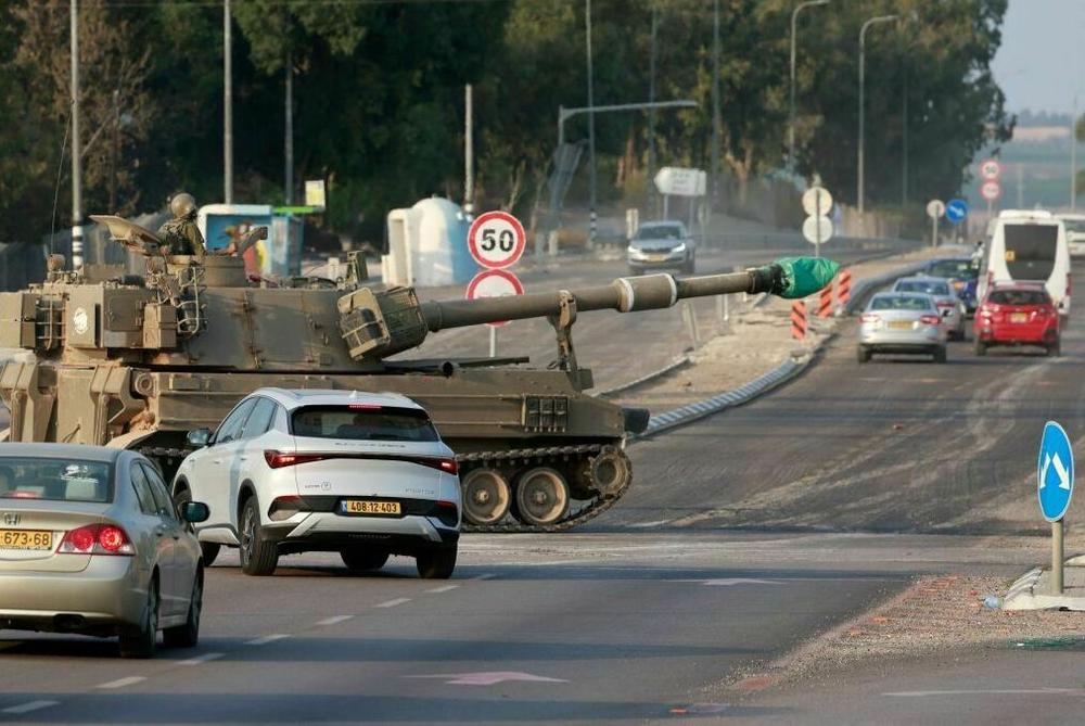 Sun., Oct. 8: Israeli forces cross a main road in their self-propelled howitzer as additional troops are deployed near the southern city of Sderot.