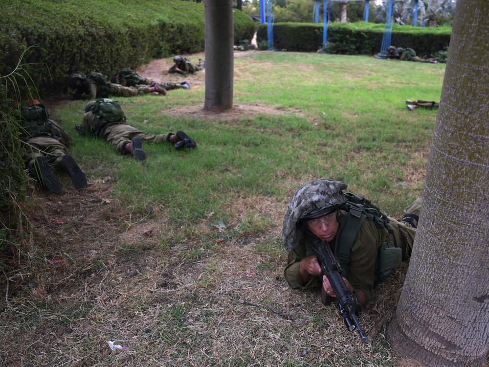Israeli soldiers are shown taking cover in Sderot on Monday, Oct. 9, 2023, during a rocket attack from the Gaza Strip.