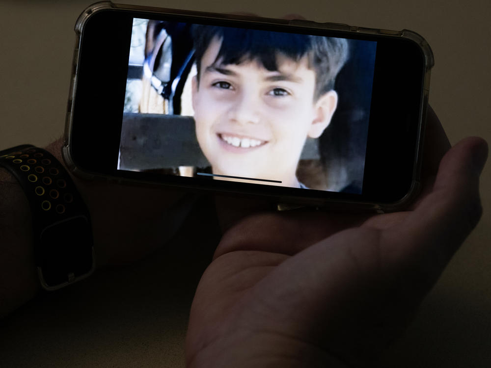 Ido holds a photo of his nephew, Erez, who is 11 years old, on his phone in his hand. Erez is feared to be have been abducted and there is a video circulating believed to show the moment a Hamas fighter grabbed him.