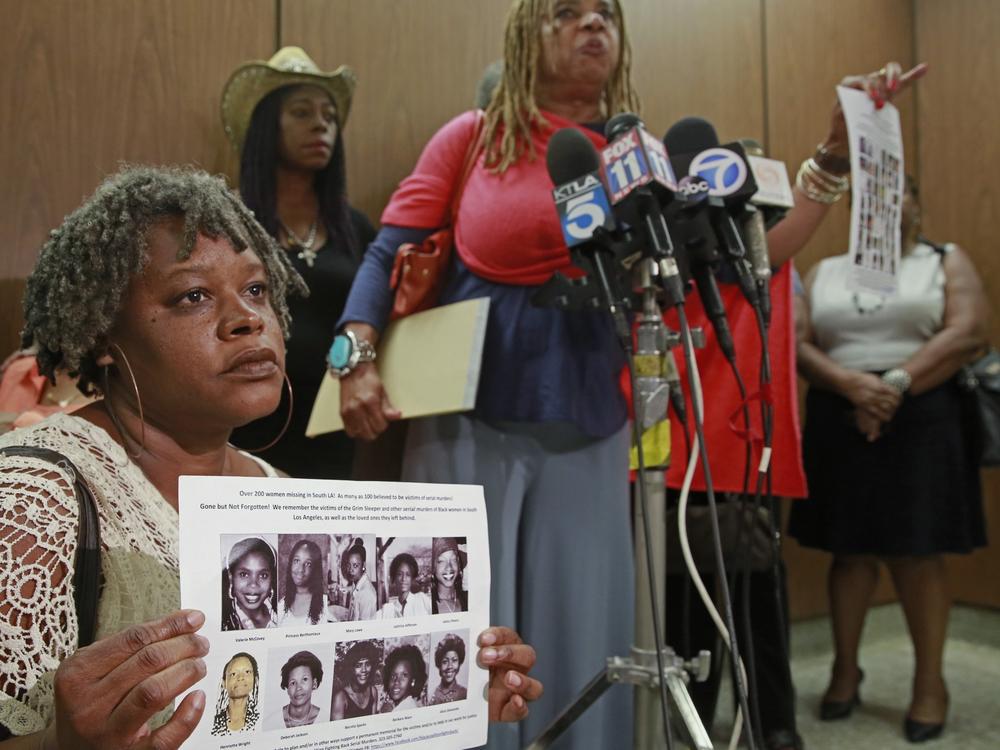 Black Coalition Fighting Back Serial Murders members Suzette Shaw, left, holding photos of 10 victims, and Margaret Prescod, at podium, join relatives of victims speaking after the sentencing for Lonnie Franklin Jr., a convicted serial killer known as the 