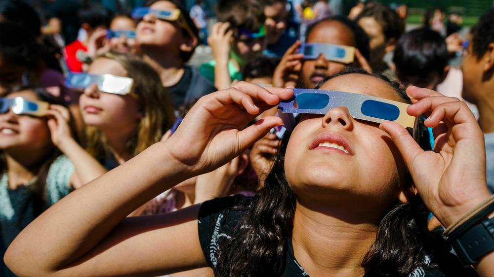 Pupils, wearing protective glasses, look at the partial solar eclipse in Schiedam, the Netherlands, on June 10, 2021.
