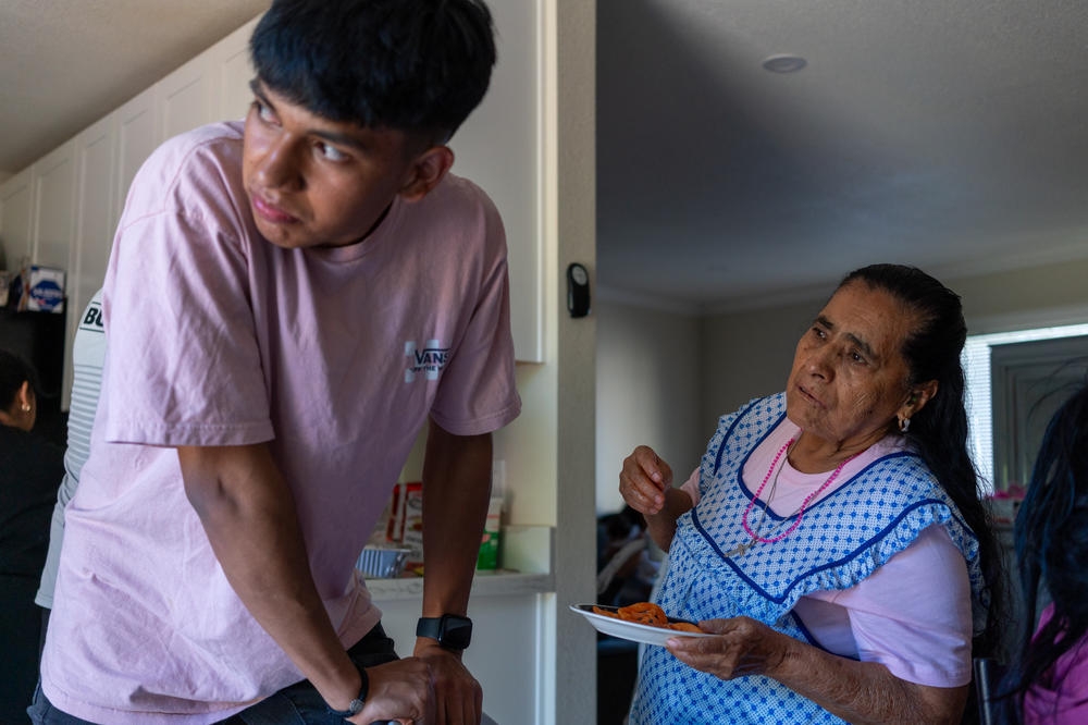 Kevin talks with his grandmother during the tacos de carnitas gathering the day after his birthday party. His grandmother came to California for the celebration. Kevin and his family used to share the same house in Michoacán; after they left, his grandfather died of COVID-19.