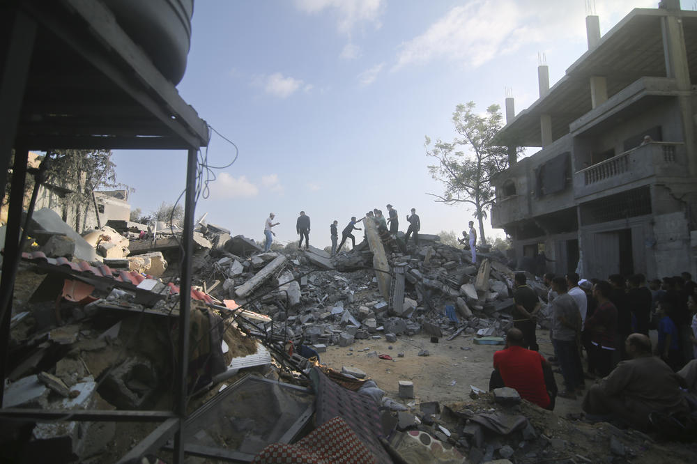 Palestinians stand by a building destroyed in an Israeli airstrike in Rafah in the Gaza Strip on Saturday.