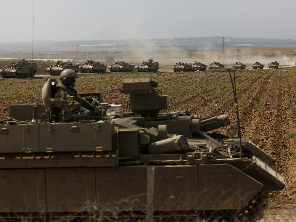 Tanks move in formation near the border with Gaza on Saturday near Sderot, Israel.