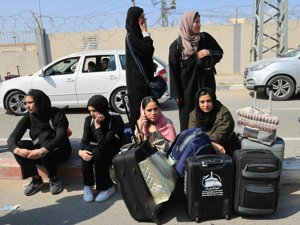 Palestinians with foreign passports wait at the Rafah gate hoping to cross into Egypt on Saturday as Israel's attacks on the Gaza Strip continue.