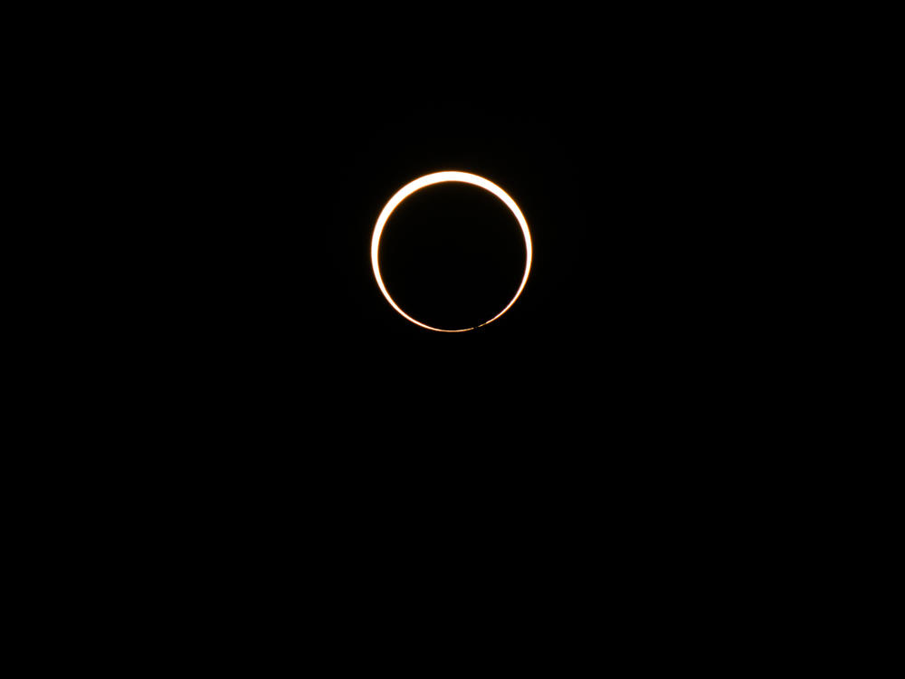 The moon begins its descent below the sun's horizon during an annular solar eclipse on October 14, 2023 in Kerrville, Texas.