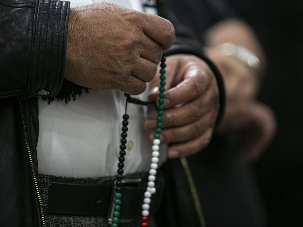 A person identified as a family member of the slain 6-year-old boy holds prayer beads at a news conference at the Muslim Community Center on Chicago's northwest side on Sunday.