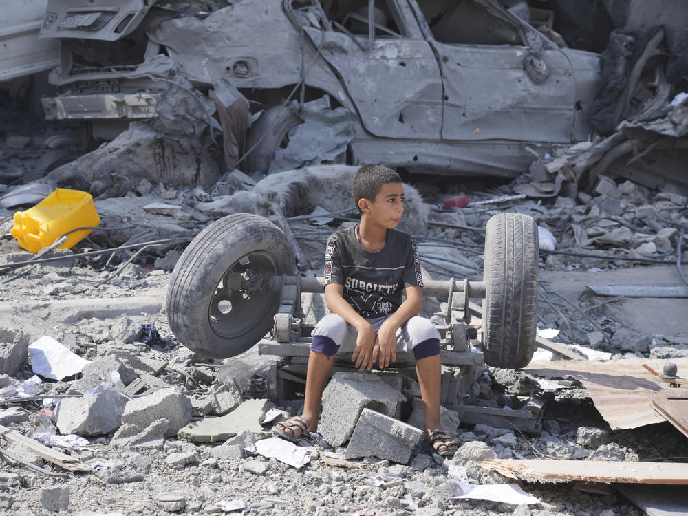 A Palestinian boy sits on the rubble of his building destroyed in an Israeli airstrike in Nuseirat camp in the central Gaza Strip on Monday.