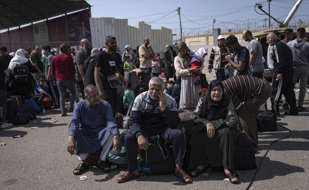 Palestinians wait at the Rafah border crossing at the southern end of Gaza, hoping to cross into Egypt on Monday. Negotiations to open the crossing, at least partially, are underway.