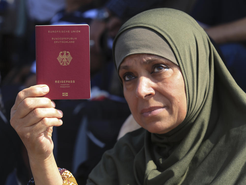 A Palestinian-German woman shows her German passport at the Rafah border crossing between the Gaza Strip and Egypt on Saturday. The crossing point remains closed, but is a potential route for foreign passport holders to leave Gaza, and for humanitarian supplies to enter as the Mideast crisis worsens.