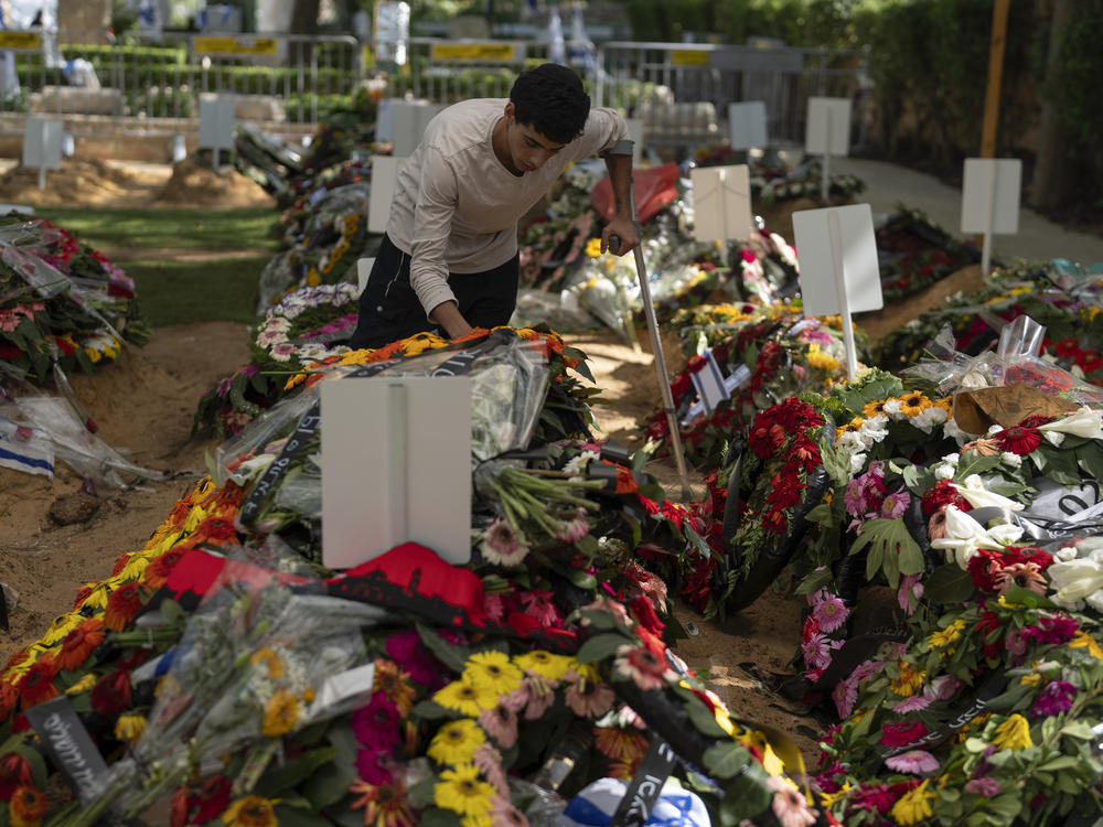 Liyam, who gave only his first name, pays respect at the grave of his fellow commander, at Mount Herzl military cemetery in Jerusalem on Monday.