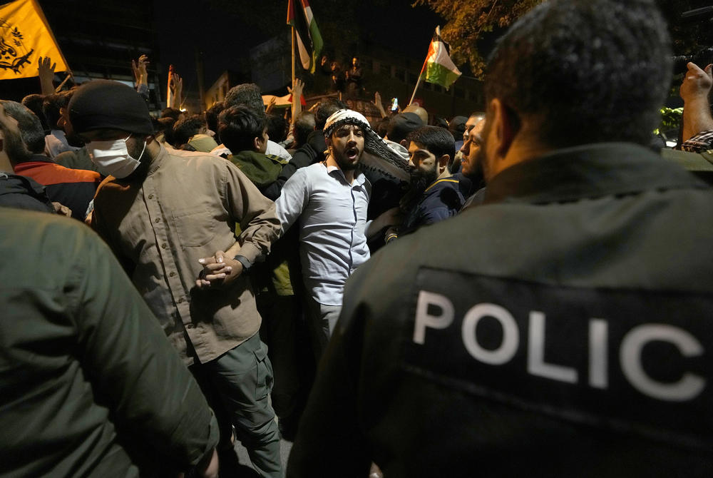 Weds., Oct. 18: Some protesters try to stop other protesters not to attack the French Embassy in Tehran, Iran during an anti-Israel protest.