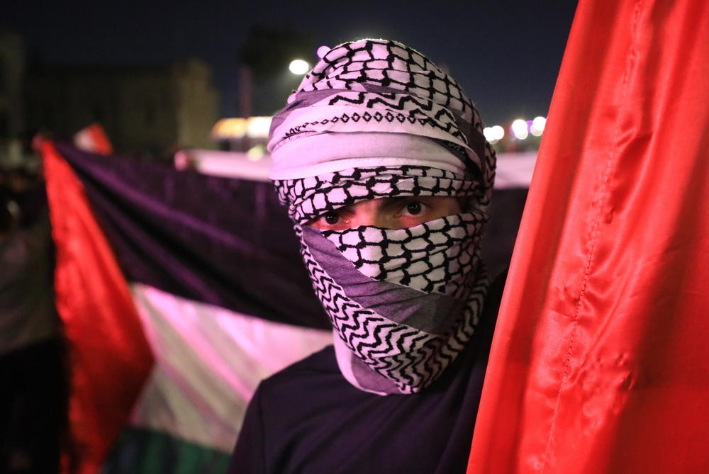 Weds. Oct. 18: A man poses with a Palestinian flag as people gather in Tahrir Square of Baghdad, Iraq to protest.