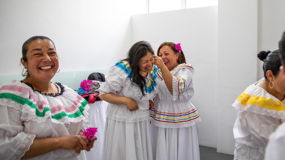 Ruth Infante (second from left), a single mother of three, and her classmates donned traditional flowing dresses for their <em>Cumbia</em> dance performance at a 