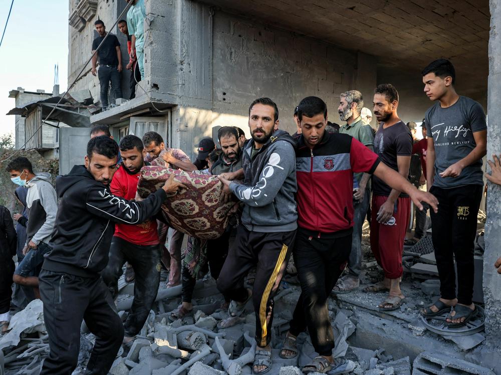 Men carry out the body of a victim from a building in Rafah in the southern of Gaza Strip as the Israeli bombardment continued Thursday.