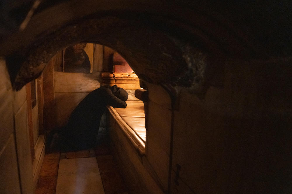 A woman kneels in what is thought to be Jesus' tomb in the Church of the Holy Sepulchre in Jerusalem on Sunday.