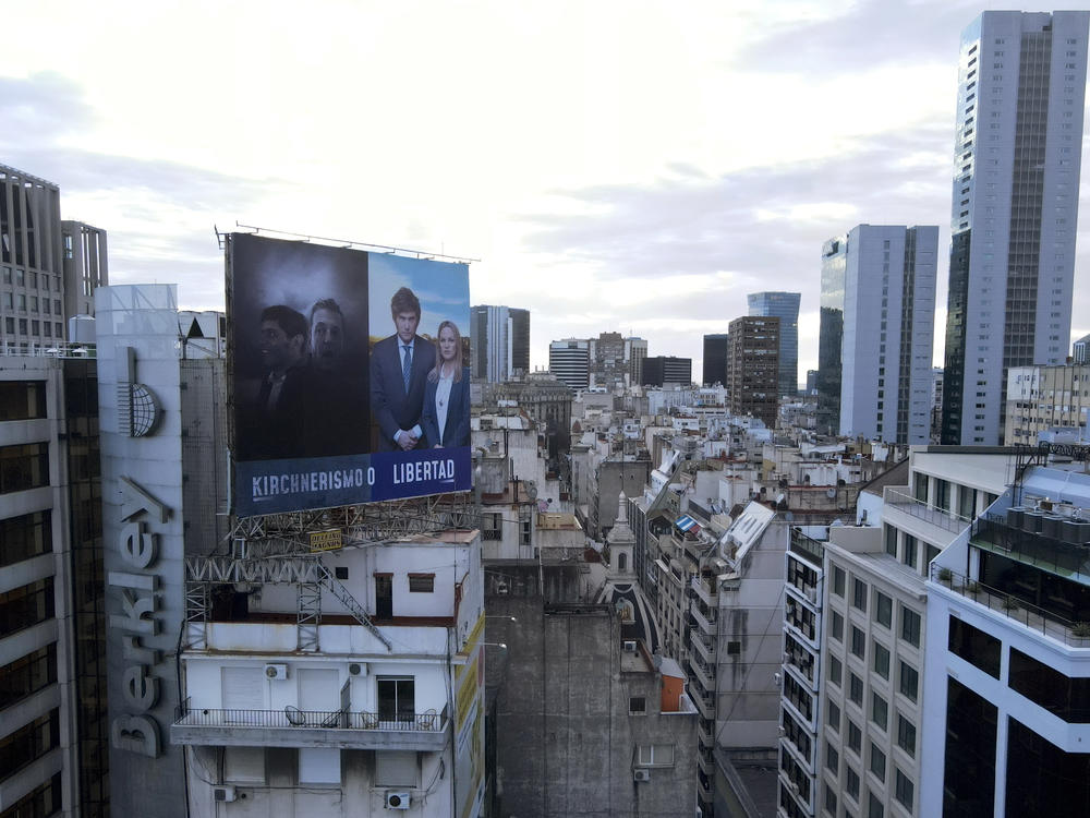 A billboard sign for presidential candidate Javier Milei and Carolina Piparo who is running for the governorship of Buenos Aires province, is juxtaposed with photos of current Economy Minister Sergio Massa, also running for president, and current governor of Buenos Aires province Axel Kicillof, and reads in Spanish: 