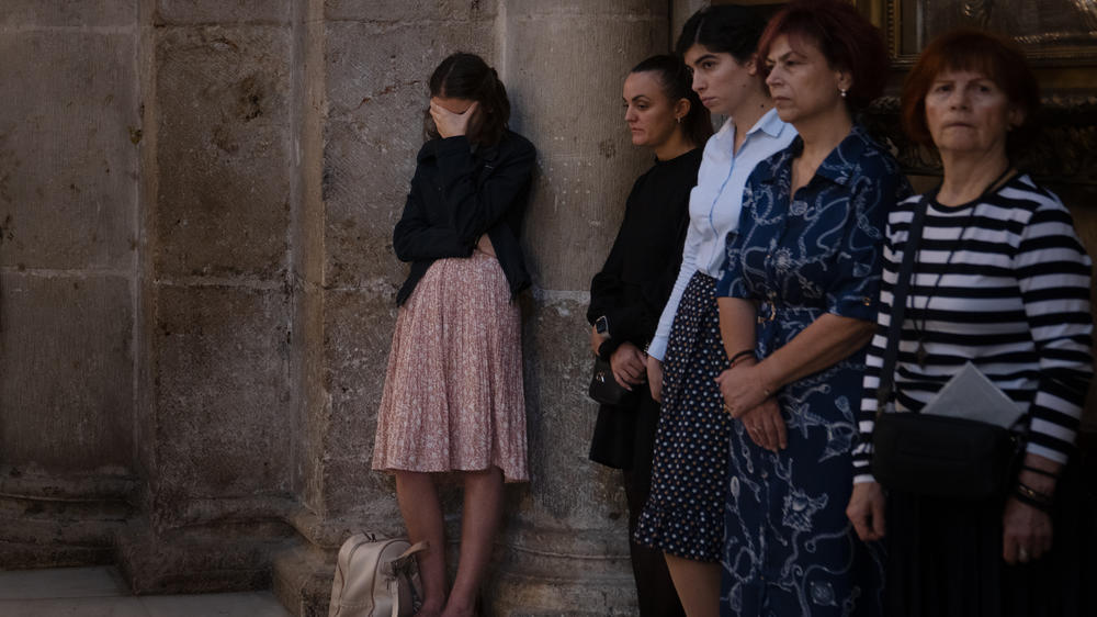 A woman covers her face at a special prayer service for the victims of an airstrike at a Gaza church, held Sunday at the Church of the Holy Sepulchre in the Old City of Jerusalem.